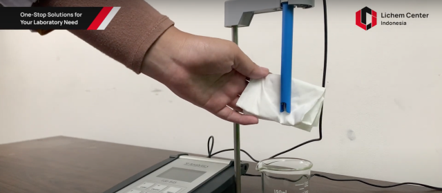 Menyeka elektroda pH dengan tissue