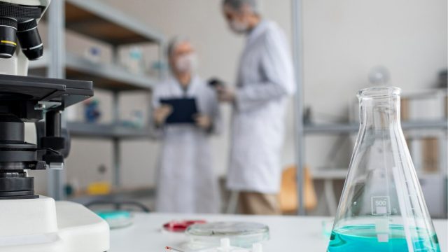 dua orang analis kimia sedang-berdiskusi di laboratorium